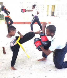 Yusuf Hopkinson delivers a sharp left foot kick as Sensei Newton holds the strike pads during training sessions.