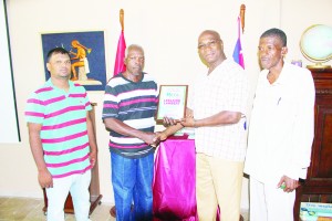 RHTYSC Executive Keith Hicks hands over award to Leslaine Lambert in presence of RHTYSC Mark Papannah and RHT IMC member Grey Butcher.