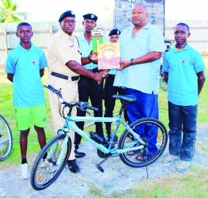 RHTY&SC’s Hilbert Foster hands over one of the items to Assistant Superintendent Terrence Browne in the presence of others. 