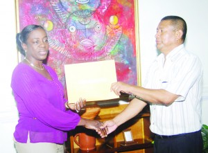  Sports Minister Nicolette Henry presents the $400,000 cheque to GVF President John Flores at her Main Street Office yesterday. 