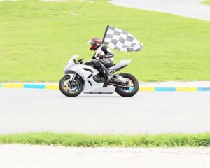 Bushy Park hero Guyana’s Stephen Vieira displays the chequered flag following one of his victories last weekend.