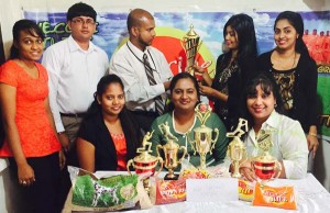 Goodwill promotions representative Abel Seetaram accepts one of the prizes from Alisha Rasheed of Nand Persaud and Company in the presence of staff members.