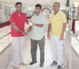 Proprietor of Steve’s Jewellery, Steve Naraine (left), presents the bracelets to GFSCA member Dharam Persaud in the presence of GFSCA Vice-president, Ricky Deonarain.