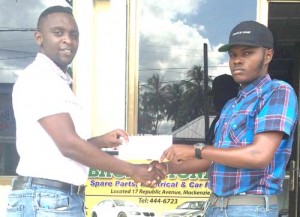 Broad Money Spare Parts’, Duquan Rose (right) hands over the sponsorship to Aubrey Major Jr. yesterday in Linden ahead of the start of the Stag/Cell Smart Second Annual Futsal Tournament tomorrow at the MSC Hard Court.