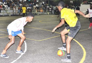 Magic Stars forward, Clarence Huggins (right) puts the moves on his defender Friday night at the MSC Hard Court in Linden in the NEE Second Annual Stag/Cell Smart Futsal Tournament.