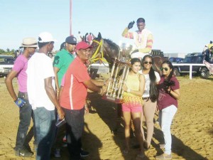 Connections of the Jumbo Jet stable are all smiles as they receive the winning trophy in the three year old event.