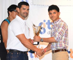 Caribbean Superbike champion Elliott Vieira receives his trophy from a sponsor representative during the presentation ceremony.