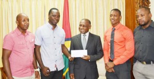 Foreign Affairs Minister Hon. Carl Greenidge (Centre) throws his support behind their team to win the Banks Beer fustal tourney on Friday after meeting with the organizers. 