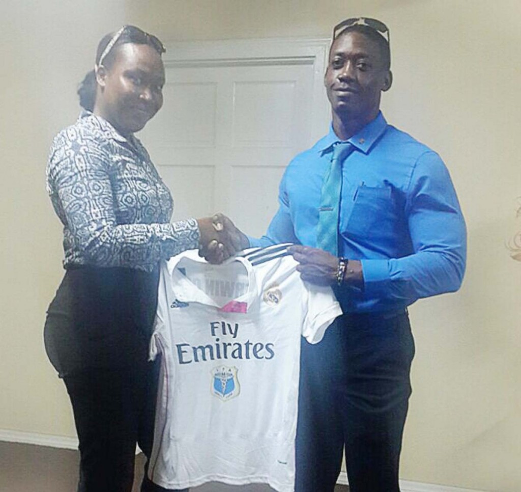 IPA Sales and Marketing Manager, Ms. Atisha Isaacs (left) hands over one of the tops to Kerwyn Clarke.