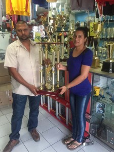 Garey Randeo on behalf of Jumbo Jet collects one of the trophies from Mrs. Devi Sunich of Trophy Stall.