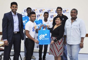 GTT Marketing Manager Anjanie Hackett (2nd right) hands over a gift to Ronaldo Renee in the presence of PRO Allison Parker (right), Charles Ramson Jr (left), Robin Singh (3rd right) and the other two cricketers. 