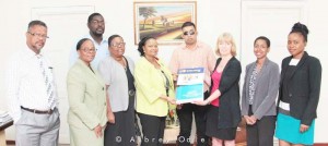 (From left) Social Protection Minister Minster Volda Lawrence receives the pieces of legislation from Marianne Flach, UNICEF Representative for Guyana and Suriname.