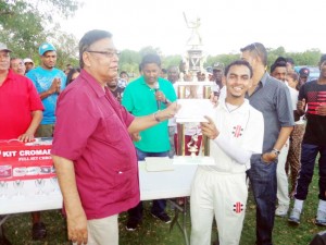 Dr. Pooran Seepersaud (left), proprietor of Hotel Riverton Suites hands over the winner’s trophy and cash to Skeldon Captain Deon Esau.