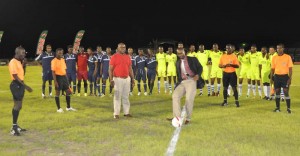 GFF President Wayne Forde officially kicks off the  tournament with VP Rawlston Adams to his right, players and officials observing his skills.