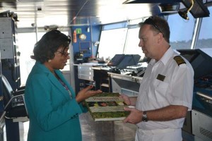 Minister of Tourism Cathy Hughes presents a book on the Rupununi to Captain of the Minerva Neil Broomhall yesterday (GINA photo)