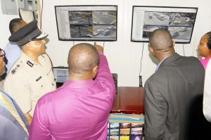 Superintendent Brian Eastman (centre)demonstrates some of the capabilities of the software to Police Commissioner Seelall Persaud (left) and Public Infrastructure Minister David Patterson