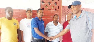 Some of the members of the Essequibo board Mr. Travis Simon (left) being congratulated by Leonard Harprashad (right) on the latter’s trip to Essequibo.