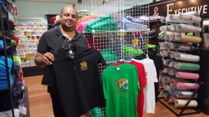 BranderZ Guyana CEO, Martin Brock, alongside some of his company’s promotional T-shirts for Guyana’s upcoming 50th Independence Day celebrations.