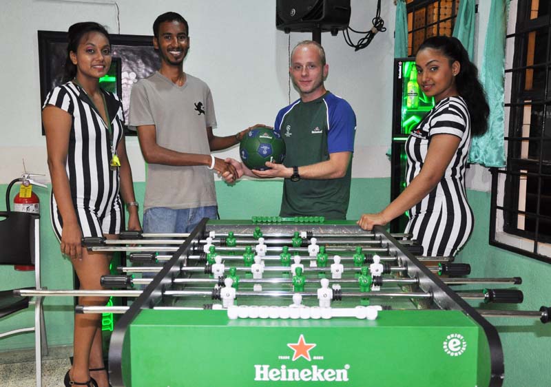 Michael Sparrock (second, left) collects his UEFA Champions League-branded football from Heineken Brand Manager, Robert Hiscock Saturday at Buddy’s Pool Hall, Sheriff Street while Heineken models share the moment.