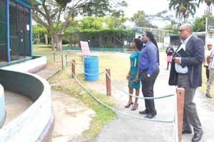 Minister of Natural Resources, Raphael Trotman (right), inspecting one of the cages