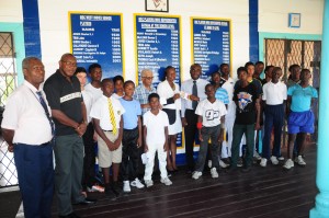 CEO of Global Seafood Distributor Allison Butters-Grant (left) presents the cheque to MSC secretary Adrian Smith in the presence of young cricketers and officials of the club and sponsors. 