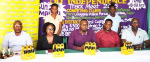 Director of Sport, Christopher Jones (centre) is flanked by North Georgetown District Manager, Mariska Williams and Marlon Laing (on his right) and Courts’ Marketing Manager, Pernell Cummings and Banks DIH Non-Alcoholic Brand Manager, Clayton McKenzie (on his left) with athletes standing behind at the launch yesterday.