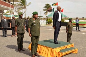 Commander-in-Chief of the Guyana Armed Forces, President David Granger (on the dais) GDF Chief of Staff, Brigadier General Mark Phillips (first left) and Colonel George Lewis (right)  take the salute as the Guyana Defence Force ranks march pass.