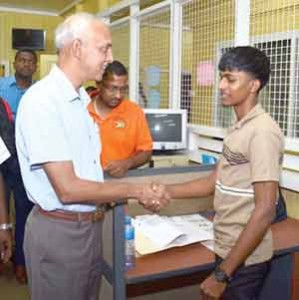 Minister of Communities Ronald Bulkan greets a young staff member of the Region Five RDC.