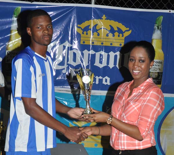 Shane Luckie receives the Highest Goal Scorer prize from Top Brandz, Corona Beer Representative, Ms Lise Lewis. 