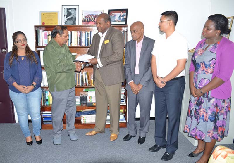 Prime Minister Moses Nagamootoo receives the final report from Convenor of the Steering Committee on Constitutional Reform, Nigel Hughes. Also in photo are the other committee members.