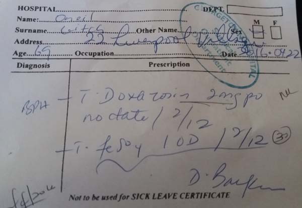 A patient showing his referral prescription slip. 