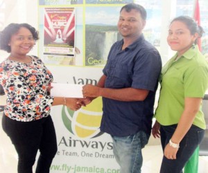 RHTYSC, M.S Executive Member Mark Papannah (centre) receives the package from Ashanti Thorne, Human Resources Officer, while Elizabeth Seepaul, Accounts Supervisor, looks on.