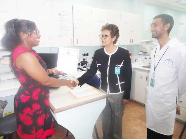 Ms. Evadnie Enniss at (left) hands offer the certificate to Dr. Madhu Singh 