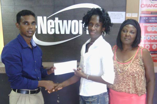 Event Co-ordinator Lorrieann Adams (second right) receives the cheque for an undisclosed sum from E-Networks representative in the presence of Avril Black recently.