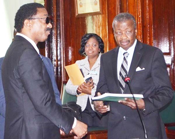 Minister of Legal Affairs Basil Williams presents a copy of the report to Speaker of the National Assembly, Dr. Barton Scotland.