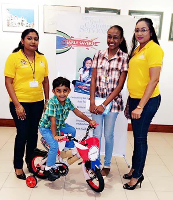 Some of the winners of the Early Savers Prize Presentation pose with Ms. Pamela Binda, Public Relations and Marketing Manager and Ms. Devi Persaud, Marketing Assistant