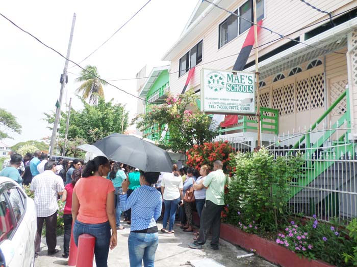 Some of the upset parents congregate outside of the school yesterday.