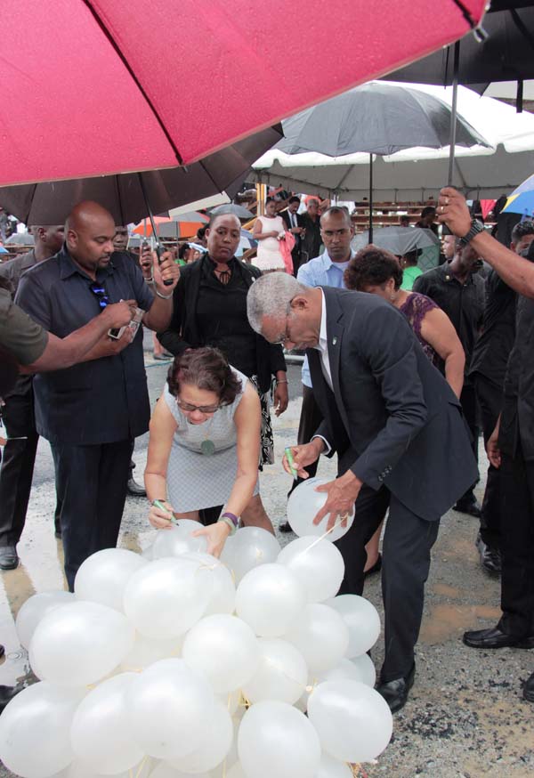 President Granger and First Lady Sandra Granger write personal messages on white helium balloons which were subsequently released at the event.