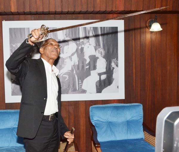 President David Granger holds the sword closer to the light to examine its condition.