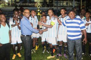 Eagles FC Captain Javair Smith being presented with winners’ trophy by UDFA President, Sharma Solomon.