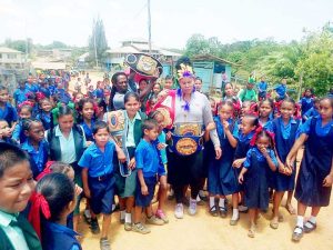 Gwendolyn O’Neil poses with children from one of the schools  in Region 1 where she hails from during her last visit home.