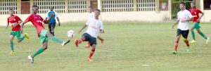 Players from Kwakwani Secondary (white jerseys) and Mackenzie High School fight for possession of the ball during their clash yesterday at Wisburg ground. 