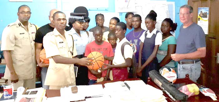 Officials of Olendorff Carriers and the Police along with several youths at the recent visit and hand over of sports gear.