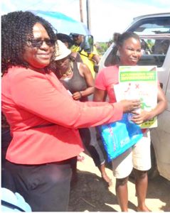 A resident receiving flood relief from Minister Cummings