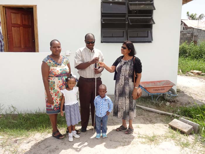 Photo saved as gafoors in Sunday Caption: Administrator of the Gafoor Foundation Mrs. Gafoor hands over keys to the house to Oliver Kerr and his family.