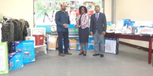 Minister Karen Cummings (centre) receives the donation from Dr. Abdel Bari. Also in photo is Hope for the Nation Secretary, Otillo Pereira.