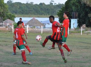 Charity’s Andron Allen (center) attempts to clear the ball.  (Zaheer Mohamed photo)