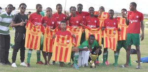 The victorious Chase Academy  display the new set of complete uniforms they were presented with along with trophies won. Inspirational Coach Vurlon Mills (2nd left) soaks in the action.  