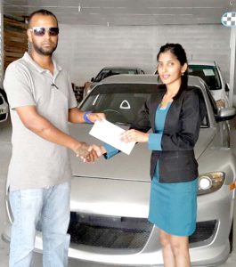 Mona Rohoman representing BM Soat Auto sales presents the sponsorship cheque to Rovin De Souza of the Guyana Cup Organising Committee. 