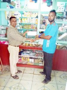 Mr. Khemcham Bemal (left) Proprietor of Prem’s Grocery and Beer Garden of Wiredam, Bush Lot, West Coast Berbice, presents the cheque to Rovin De Souza of the Guyana Cup organising committee. 